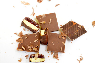various chocolates and peels on white background, top view