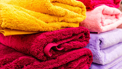 Pile of colorful towels: A neatly stacked pile of colorful, soft towels in various shades, inviting comfort and freshness.