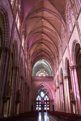 Fototapeta premium Innenraum der Basilica del Voto Nacional in Quito mit Lichtspiel durch bunte Fenster 