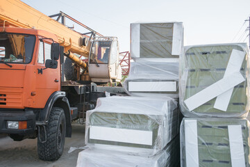 Construction site with heavy machinery and stacked cargo during daytime work in an industrial area