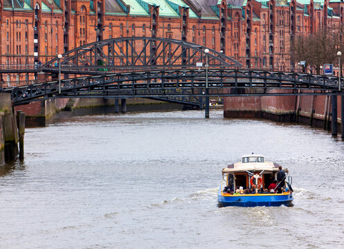 Harbor tour boat on a canal at the historic warehouse district Speicherstadt Hamburg