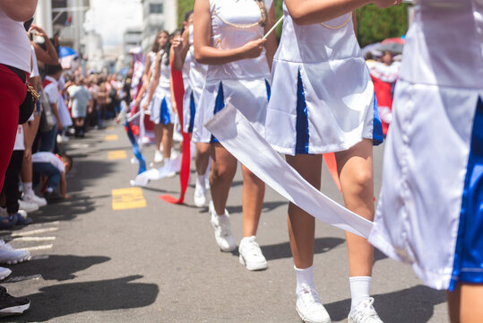 Young majorettes dressed in white and blue perform with ribbons during Costa Rica's Independence Day street celebration. 
