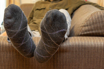 ソファーに横たわる男性の足