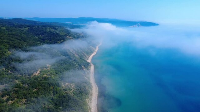 Aerial panoramic view of Cape Emine on the Bulgarian Black Sea coast. Dramatic cliffs, a historic lighthouse, and turquoise waters shrouded in mysterious sea mist, captured by drone.