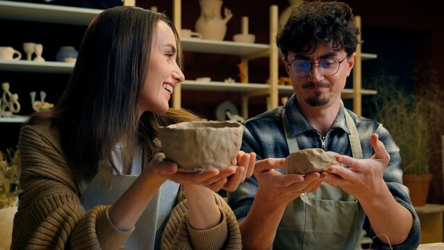 Caucasian woman man teacher student potter artist teaching sculpture ceramics clay process modeling at pottery workshop couple date girl guy creating crockery handmade eco craft studying in art studio