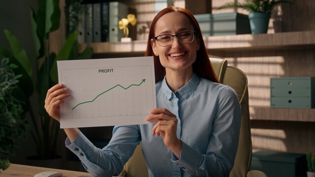Smiling business woman Caucasian happy girl investor broker businesswoman holding paper document finance good results income profit crypto trading invest diagram graph chart growth plan in office 