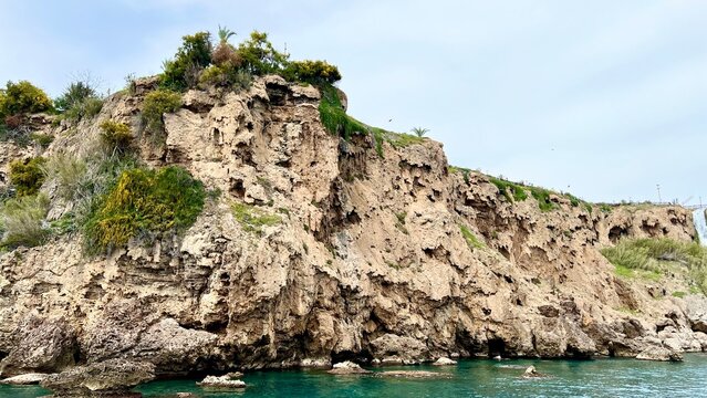 Turquoise sea with rocky cliff view. Summer vacation, Mediterranean Sea, travel, coastal landscape, nature, Antalya province, Turkey, outdoor scenery, peaceful summer day.
