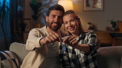 Happy family portrait evening night Caucasian couple owners new home holding keys buying apartment...
