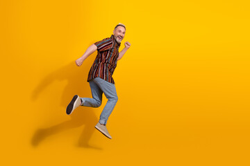 Fototapeta na wymiar Stylish man in retro print shirt posing against vibrant yellow background showcasing cheerful mood and lively personality