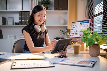 Creative female graphic designer working with digital tablet at cozy home office desk