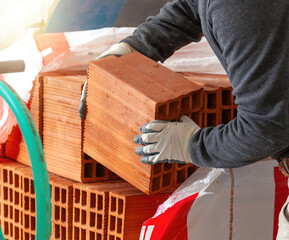 Construction worker handling hollow bricks on a building site