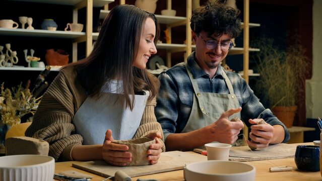 Happy woman man in pottery workshop creating handmade clay modeling class teacher student craft hobby sculpture couple date family potter artisan handcrafting ceramics have fun laughing in art studio
