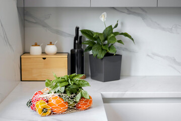Fresh vegetables and fruits in a reusable bag in the modern kitchen. Concept of healthy nutrition...