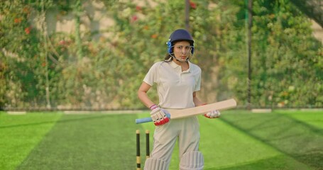 Indian gen z athlete sports woman lady standing at outdoor play ground wear white uniform and protective helmet looking at camera Asian cricket player female girl hold bat day time at match playground - Powered by Adobe