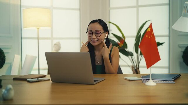 Young woman teaching Chinese language online using laptop, remote class