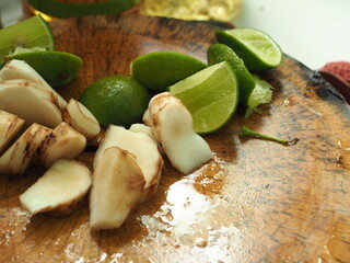 sliced galangal and lime on cutting board
