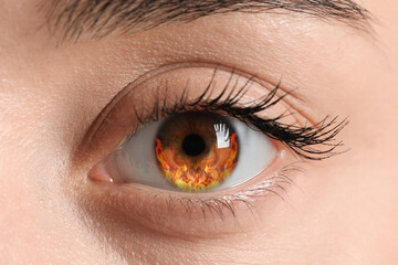 Woman with fire burning in her eye, closeup