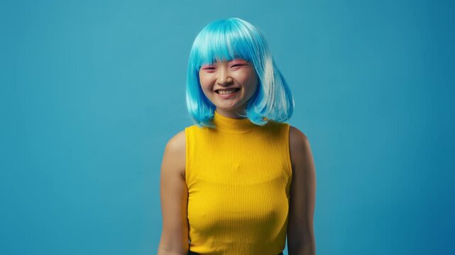 Happy Korean woman with dyed hair showing oops gesture against blue background