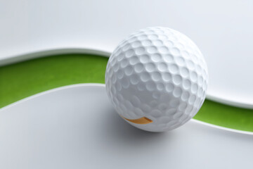 White golf ball is sitting on a green grassy area. The ball is surrounded by a green line, which creates a sense of motion and direction. The image conveys a feeling of excitement and anticipation