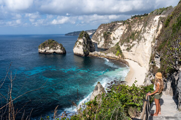 Tourist admiring nusa penida diamond beach and turquoise water in bali