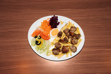 Turkish kebab plate with fries, vegetables and pork. Delicious freshly prepared meal, perfect for menus, restaurants, or food delivery concepts.