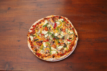 vegetable pizza on wooden background. Delicious freshly prepared meal, perfect for menus, restaurants, or food delivery concepts.