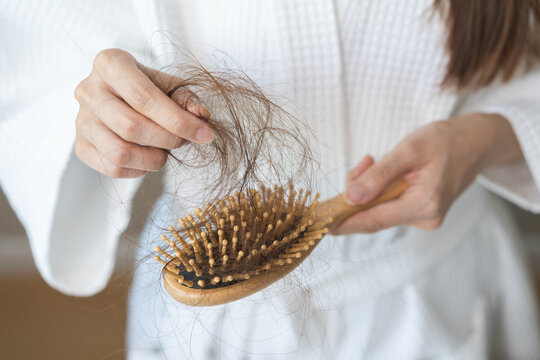 Stress asian young woman, girl hand holding comb show her hairbrush with loss, hair in brush after brushing, hair fall out problem. Health care, beauty with treatment concept, isolated on background.