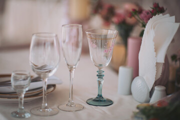 Elegant table setting featuring assorted glasses and decor in a serene dining space with delicate flowers during a daytime gathering