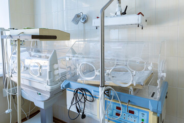 A clean, empty hospital incubator room features two transparent infant incubators.