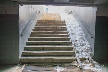 dark underground pedestrian crossing with a lift for the disabled in the snow
