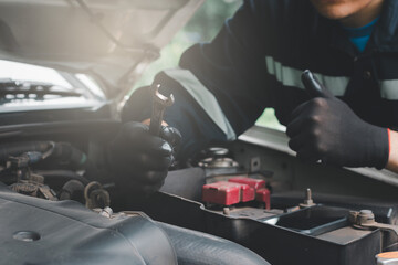 A mechanic is holding a wrench ready to inspect the engine and perform maintenance.