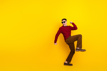 Handsome Cheerful Young Man Posing Against a Bright Yellow Background in a Stylish Outfit