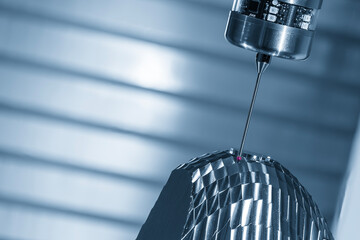 The CMM machine measure the head light lens reflection mold parts in the light blue scene.