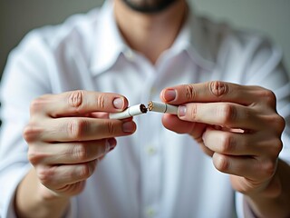 Man decisively breaking a cigarette, making the choice to quit his smoking habit for a healthier future life.