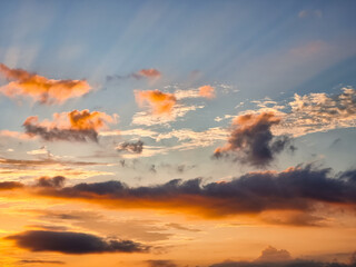 Golden sunset clouds with soft sunlight rays and colorful sky during a peaceful evening
