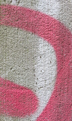Pink, white spray paint swirling across rough concrete wall, creating vibrant urban art texture with dynamic, wavy pattern