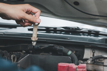 Car oil checker in garage for maintenance, repair or repair of car engine, car expert and car technician check oil level in garage.