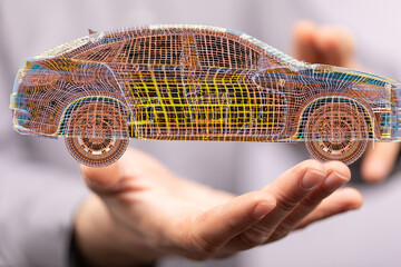 Wireframe car model in a hand, symbolizing innovation and future of automotive design.