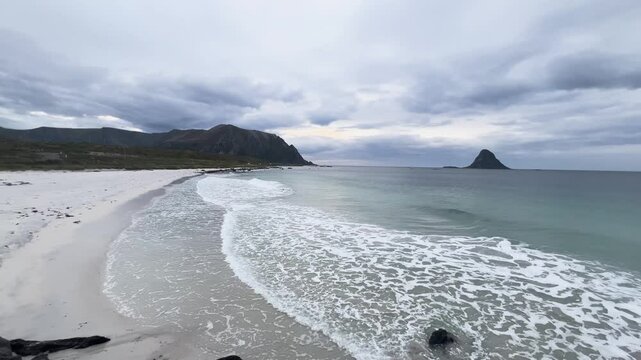 White sand beach with turquoise ocean water and a mountain in Bleik beach, Lofoten islands, Norway