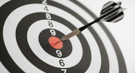 Dart in bullseye on dartboard with black and white rings. Precision target and accuracy concept for achievement and success.
