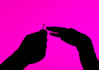 Silhouette of Hands With Nail on Pink Background