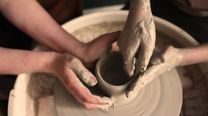 Close-up of hands working with clay on a pottery wheel in an artisan studio. Creative hobby, hands-on ceramic art and mindful handmade craftsmanship.