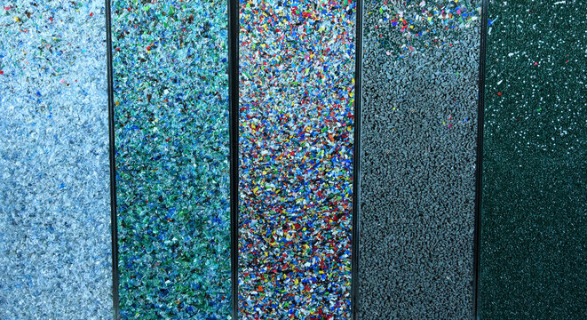 Macro close-up of colorful, granulated plastic flakes, pellets, sorted and ready for the recycling process. Chips, created from plastic waste, show  vibrant mix of colors from shades of blue and green - Powered by Adobe