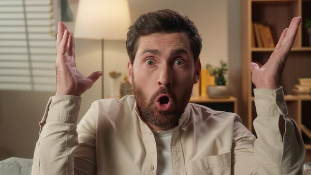 Shocked man looking at camera amazing reaction shock at home Caucasian guy amazed stunned male homeowner businessman blow mind gesture astonishment wow emotion unbelievable excitement in apartment
