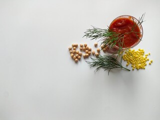 Glass of tomato juice with parsley and assorted grains on white background