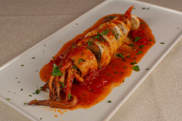 Stuffed Squid with Tomato Sauce and Herbs – Gourmet Seafood Dish on White Plate