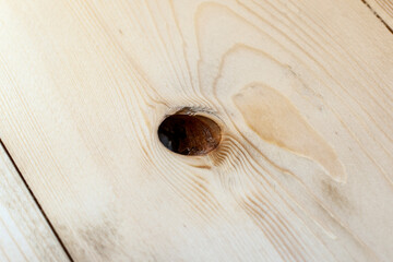 Close-up of a missing knot hole in wooden flooring highlights a common defect that must be repaired...