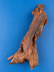 A detailed close-up of unique natural driftwood, expertly crafted to elevate the decor of aquariums or terrariums, set against a bold purple background.