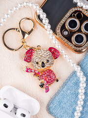 Close up of metallic gold keychain with rhinestones in the shape of pink panda with twig on the...