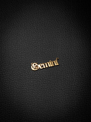 close up gold pendant horoscope with Gemini   sign on a wooden base  on a pink background
